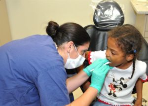 a dentist doing initial dental assessment